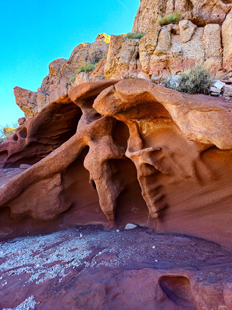 这张照片捕捉了一块独特的沙漠石头，表面布满了沙漠风雕刻的孔洞。图片下载