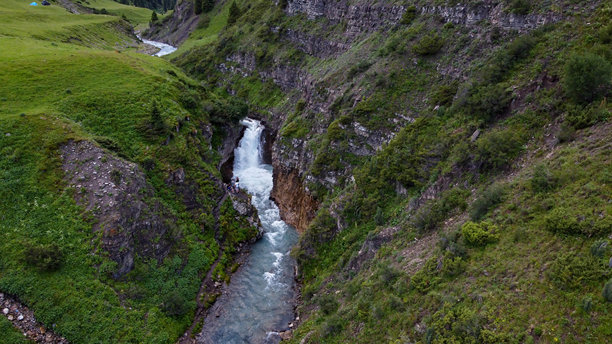 这张照片展示了特克斯瀑布的景观，周围是巨大的岩石。图片下载