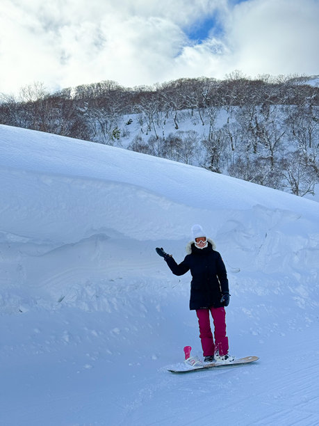 垂直：滑雪者在比她还高的雪堆前摆姿势的搞笑照片图片下载
