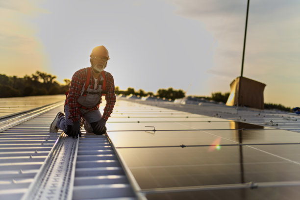 技术人员检查安装在建筑屋顶的太阳能发电厂的库存照片图片下载