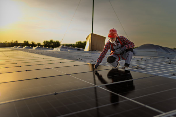 技术人员检查安装在建筑屋顶的太阳能发电厂的库存照片图片下载