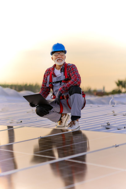 技术人员检查安装在建筑屋顶的太阳能发电厂的库存照片图片下载