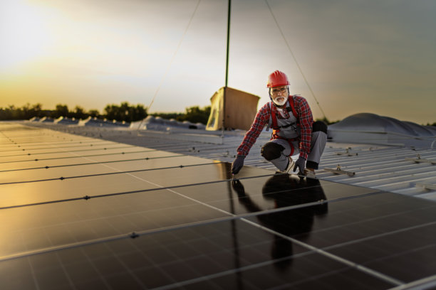 技术人员检查安装在建筑屋顶的太阳能发电厂的库存照片图片下载