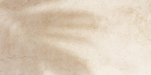 夏季横幅，俯视棕榈叶投射的阳光阴影在沙色背景上。夏季美学照片，淡米色，留白，无人，度假与放松的概念。抽象视角。图片下载