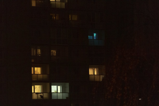 模糊的夜间建筑照片，许多窗户亮着灯。图片下载