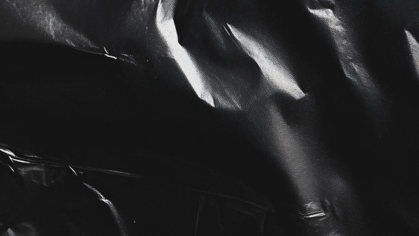 黑色透明塑料薄膜纹理叠加背景。用于海报设计和照片叠加效果的真实塑料。皱褶塑料表面图案，适用于图形设计素材和元素模型。图片下载