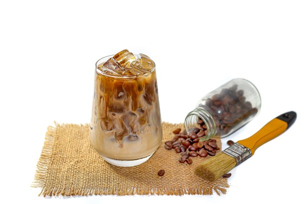 特制菜单，白色背景上的拿铁冰咖啡，搭配咖啡豆洒落在麻袋上的孤立照片风格。图片下载