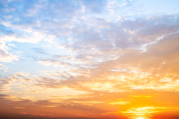 美丽奢华的柔和渐变橙金色云彩和阳光映衬在蓝天上，完美适合作为背景，拍摄于黄昏时分，清晨，超大尺寸，高分辨率的风景照片图片下载