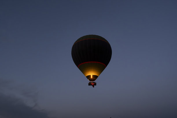 热气球在卡帕多奇亚的天空中。日出时的剪影照片。图片下载