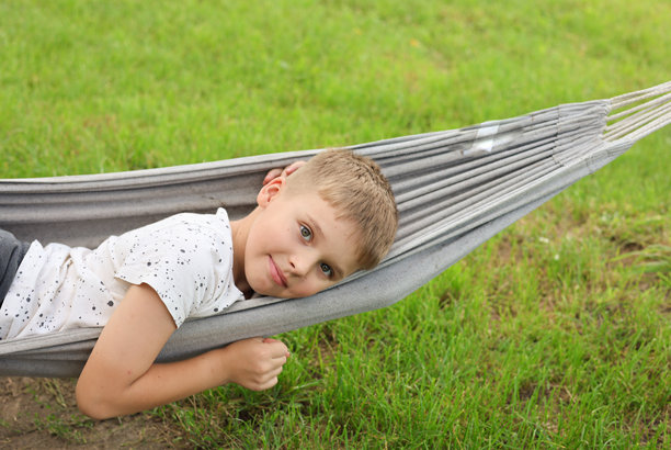 金发的白人男孩躺在吊床上，横向照片图片下载
