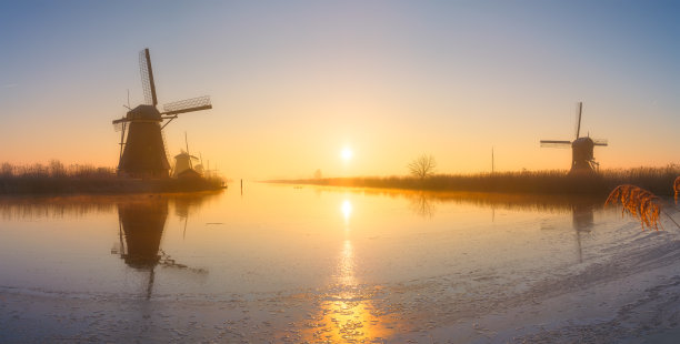 荷兰日出时的风车。雾蒙蒙的早晨和阳光。荷兰运河。全景自然风光。适合用作背景、壁纸和明信片的照片。图片下载