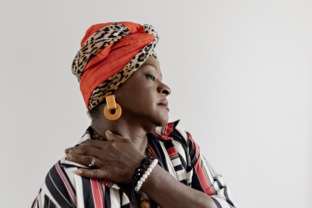 在家中拍摄母亲节照片的美丽、快乐、微笑的成熟的女性肖像。微笑的非洲女性穿着色彩斑斓的非洲服装庆祝母亲节。图片下载