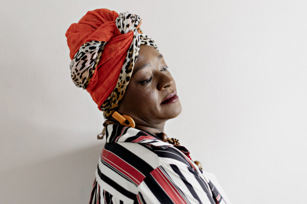 在家中拍摄母亲节照片的美丽快乐的成熟的女性肖像。微笑的非洲女性穿着色彩斑斓的非洲服装庆祝母亲节。图片下载