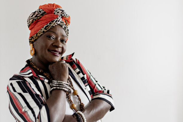 在家中拍摄母亲节照片的美丽、快乐和微笑的成熟的女性肖像。微笑的非洲女性穿着色彩斑斓的非洲服装庆祝母亲节。图片下载