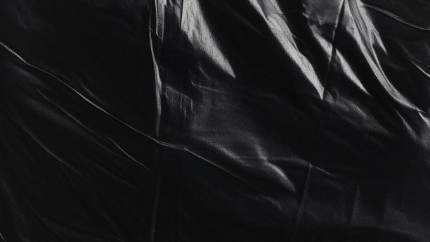 黑色透明塑料薄膜纹理叠加背景。用于海报设计和照片叠加效果的真实塑料。皱褶塑料表面图案，适用于图形设计素材和元素模型。图片下载