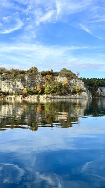 扎克日维克湖的垂直照片，岩石和天空在蓝色水面上倒影。图片下载