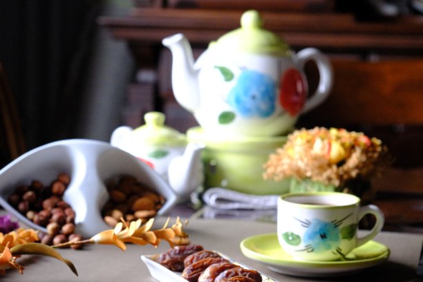 拉马丹开斋餐桌的特写照片，桌上有枣子、橄榄、茶壶和花卉装饰。图片下载