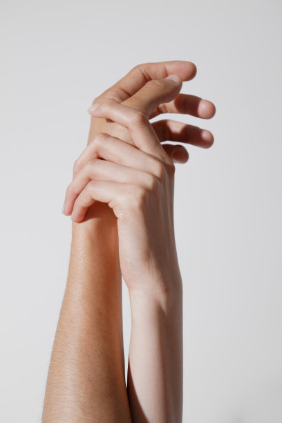 在中性化的化妆品照片中，亚洲男人和女人抚摸着手臂。图片下载