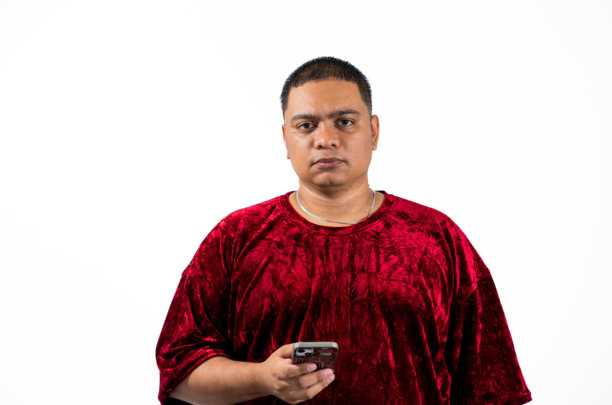 手持手机、面带严肃表情的男子肖像，背景柔和，直视镜头 - 股票照片图片下载