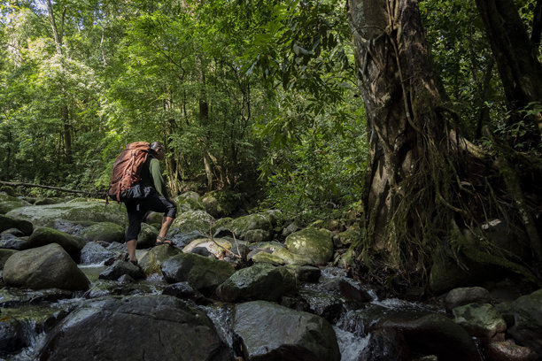 背包男士在河中行走-库存照片图片下载