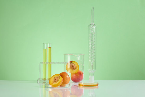 广告照片的中心是一些实验玻璃器皿，包括实验室冷凝器、烧杯、架子上的试管和装有几只桃子的培养皿。照片有正面角度和文字空间图片下载