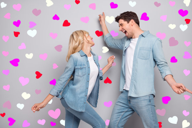 年轻情侣的侧面照片，快乐积极，微笑着在灰色背景下享受舞会派对的乐趣。图片下载