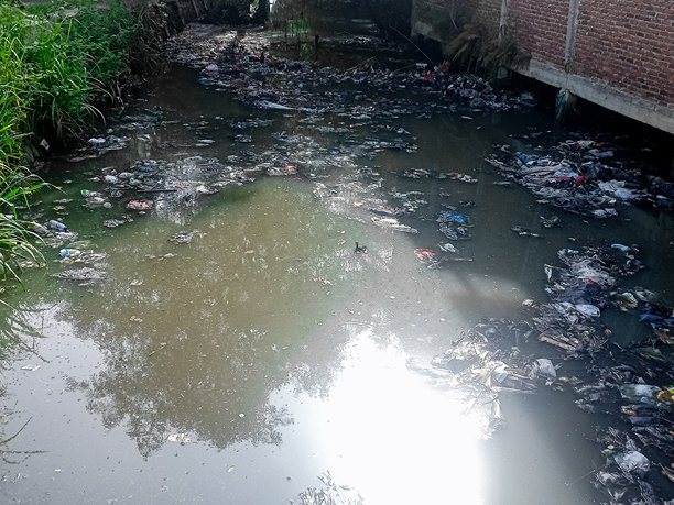 污染的河流照片，满是垃圾，展示了我们生活的环境。图片下载