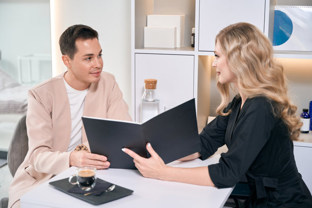 美容师向男性客户展示美容手术效果的照片图片下载