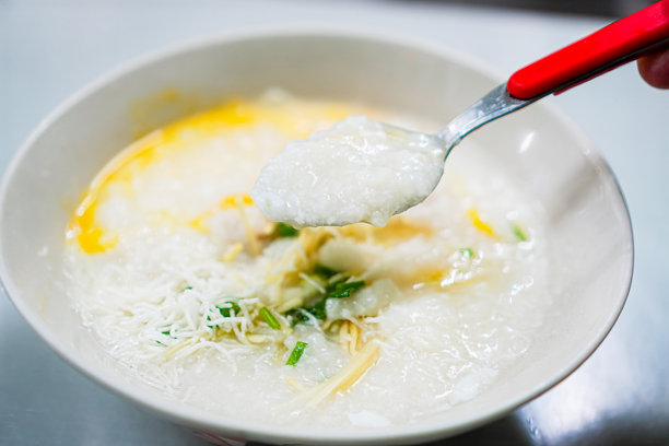 细腻煮制的米粥特写照片，是猪肉丸蛋粥的主要成分。图片下载