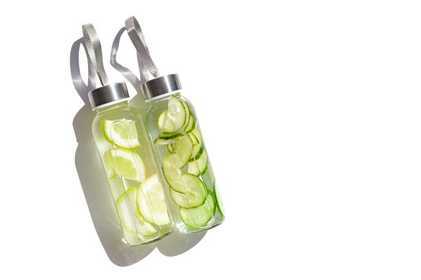 阳光下白色背景中的柠檬黄瓜水饮料，放在玻璃瓶中。健康、饮食、健康生活理念。时尚的可重复使用水瓶，环保生活方式的简约照片。图片下载