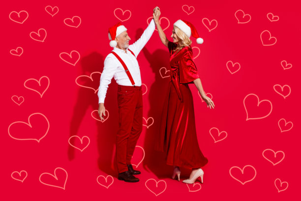成熟的夫妻在红色背景下享受圣诞舞会的全身照片图片下载