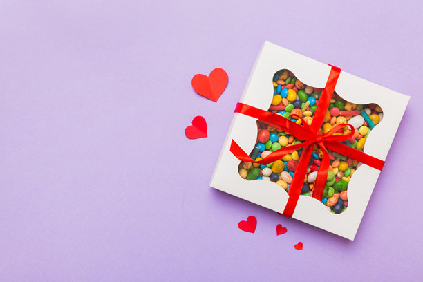 情人节构图：甜美的糖果，带有蝴蝶结的礼品盒和红色毛毡心形，照片模板，背景。俯视图，留白空间。图片下载