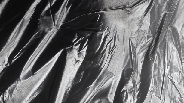 黑色透明塑料薄膜纹理叠加背景。用于海报设计和照片叠加效果的真实塑料。皱褶塑料表面图案，适用于图形设计素材和元素模型。图片下载