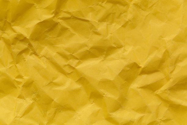 黄色皱纸纹理的特写，皱折的黄色纸张特写。细致的照片纹理背景。图片下载
