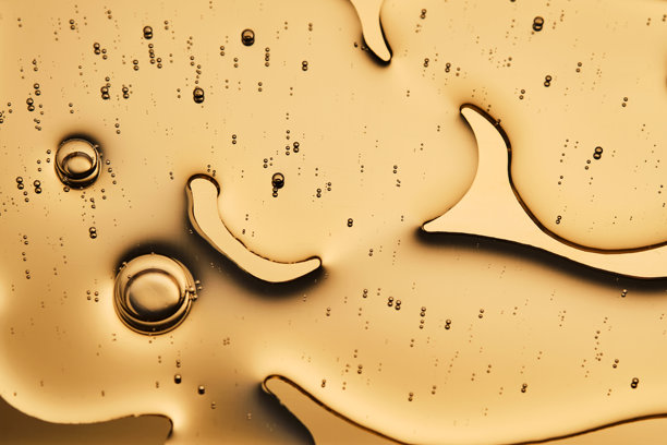 在金色背景上，化妆品精华的美丽质感占据了照片的大部分。图片下载