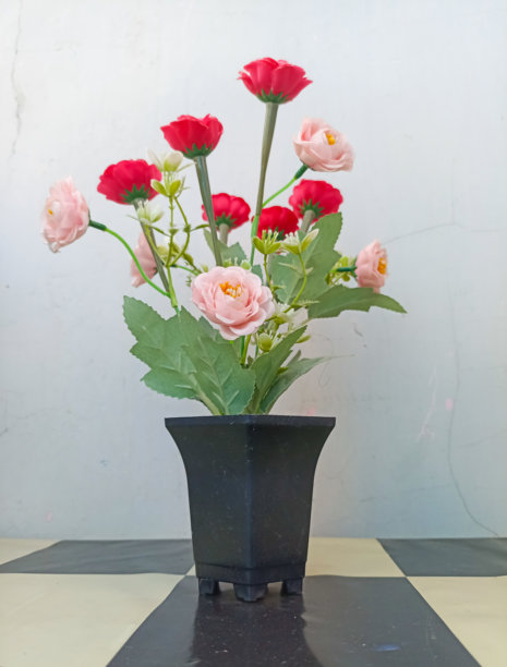 黑色花盆中的红色塑料花照片图片下载