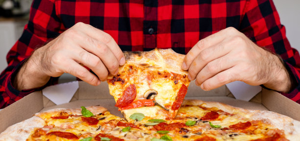男性手中拿着一片披萨的特写照片图片下载