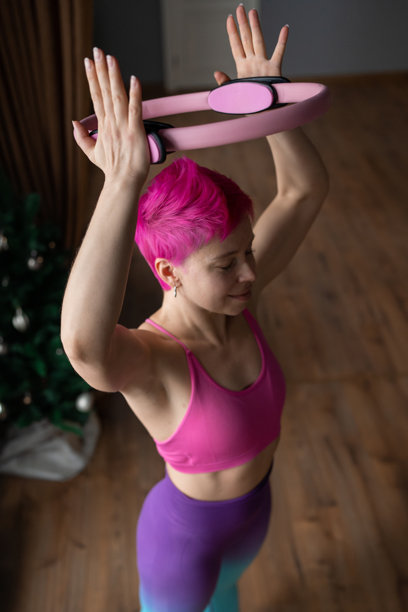 一位女性在普拉提工作室使用魔法圈进行锻炼，积极投入于运动。图片下载