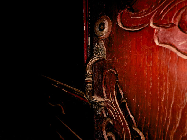 复杂的木雕，深红色表面上有旋转的花卉图案。这张照片突显了传统木工的艺术性和工艺水平。图片下载