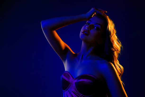 夜总会中热情迷人的舞者照片，背景为霓虹蓝色。图片下载