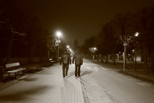 波兰索波特 - 2025年1月22日：两名男子在夜间散步，正面照明，黑白照片图片下载