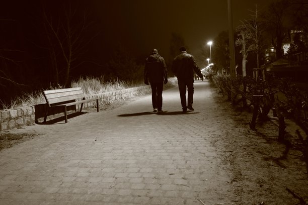 波兰索波特 - 2025年1月22日：两名男子在夜间散步，正面照明，黑白照片图片下载