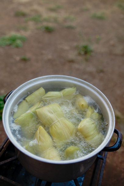 一个人在智利的家中准备用玉米棒制作的玉米饼，以及一个人在吃玉米饼的照片图片下载