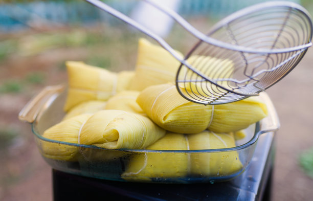 一个人在智利的家中准备用玉米棒制作的玉米饼，以及一个人在吃玉米饼的照片图片下载