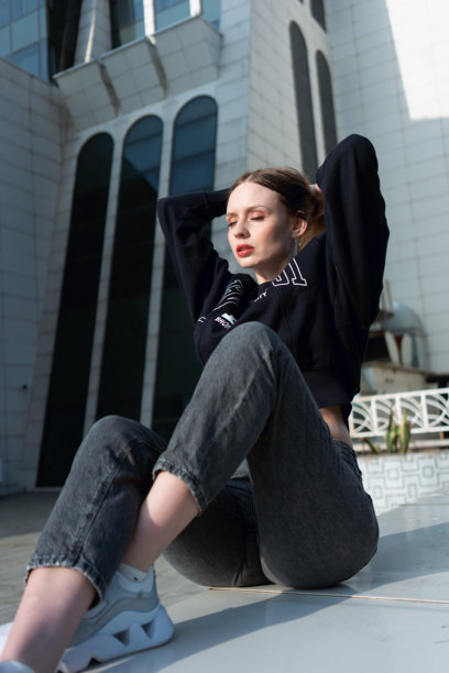 城市中穿着运动卫衣的美丽快乐女孩。肖像。时尚。高质量照片。图片下载