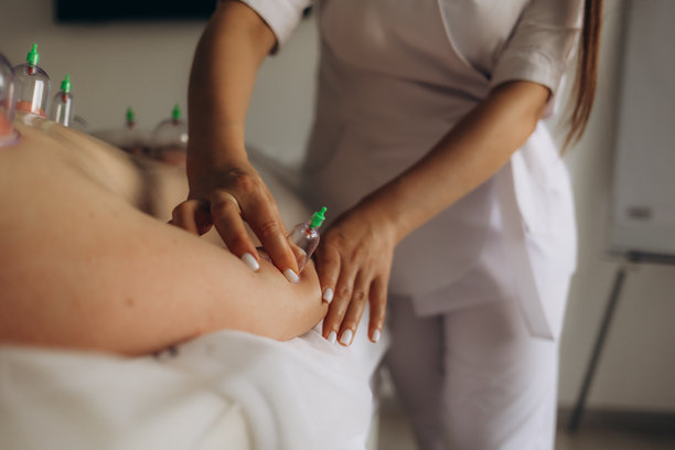 在白色背景下进行拔罐疗法的男子的真实照片。传统的整体健康护理概念。非常适合用于说明替代医学实践。图片下载