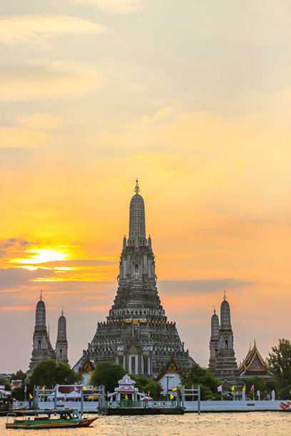 日出背景下人们聚集的古老寺庙建筑照片。图片下载
