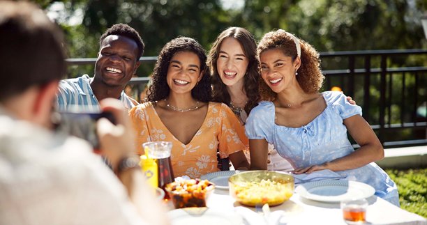 朋友、食物和微笑，户外摄影庆祝新年，社交活动或更新个人资料照片。快乐的回忆，多元化的人群，阳台上的节日午餐，增进感情和聚会。图片下载
