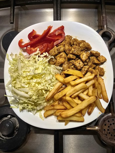 盘子上的菜肴照片，香料鸡肉、薯条、沙拉和辣椒。图片下载