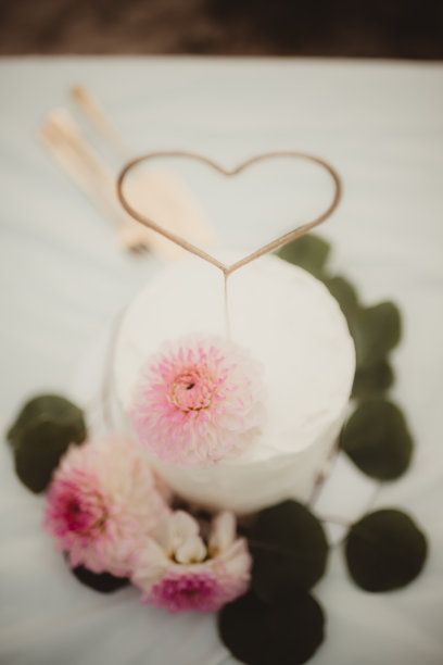 俯视简单婚礼蛋糕的照片，上面装饰着粉色花朵。图片下载